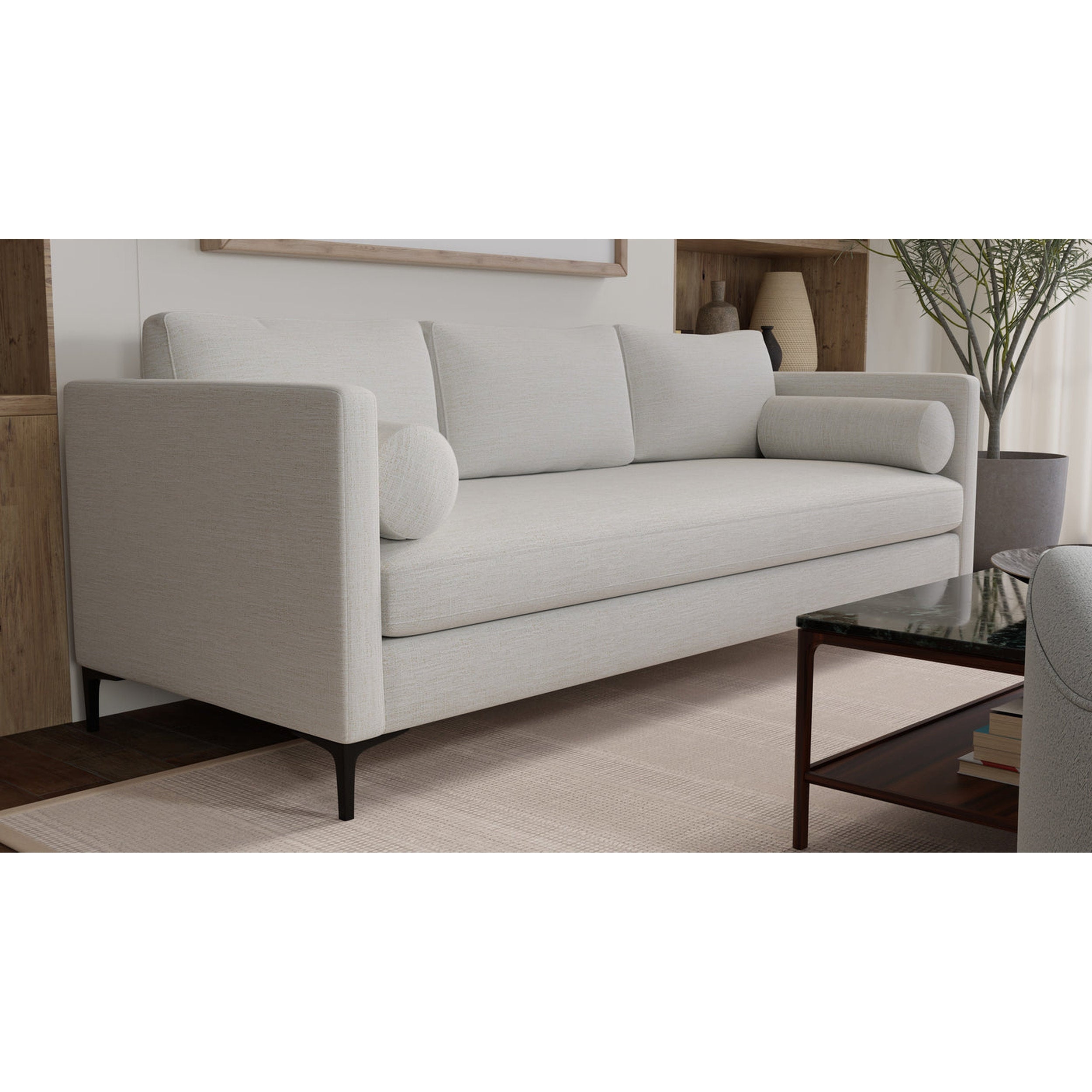 Beige sofa in a living room setting with a coffee table and decorative items.