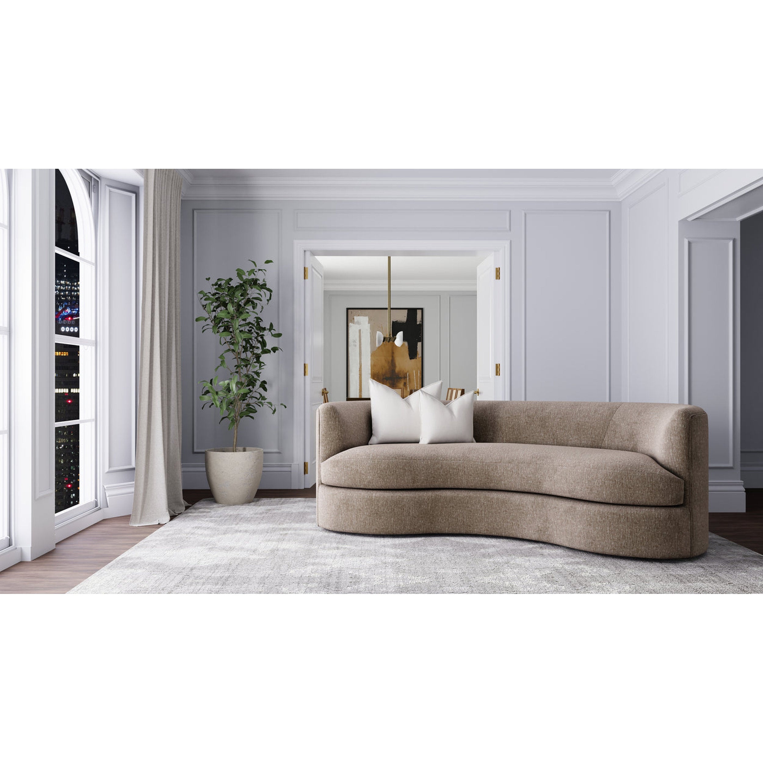 Modern living room with a curved beige sofa, white walls, and a plant.