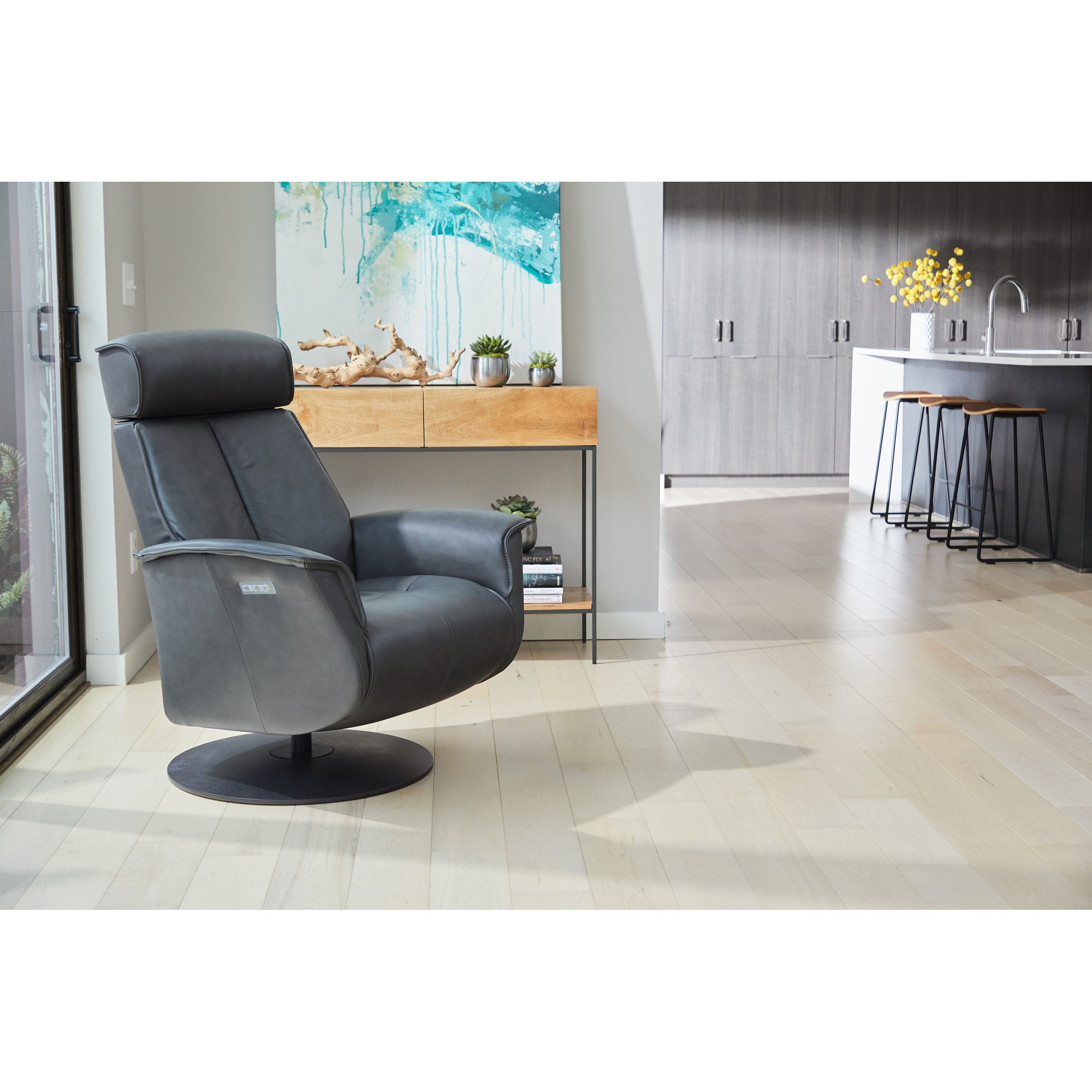 Gray recliner chair in a modern living room setting with a kitchen in the background.