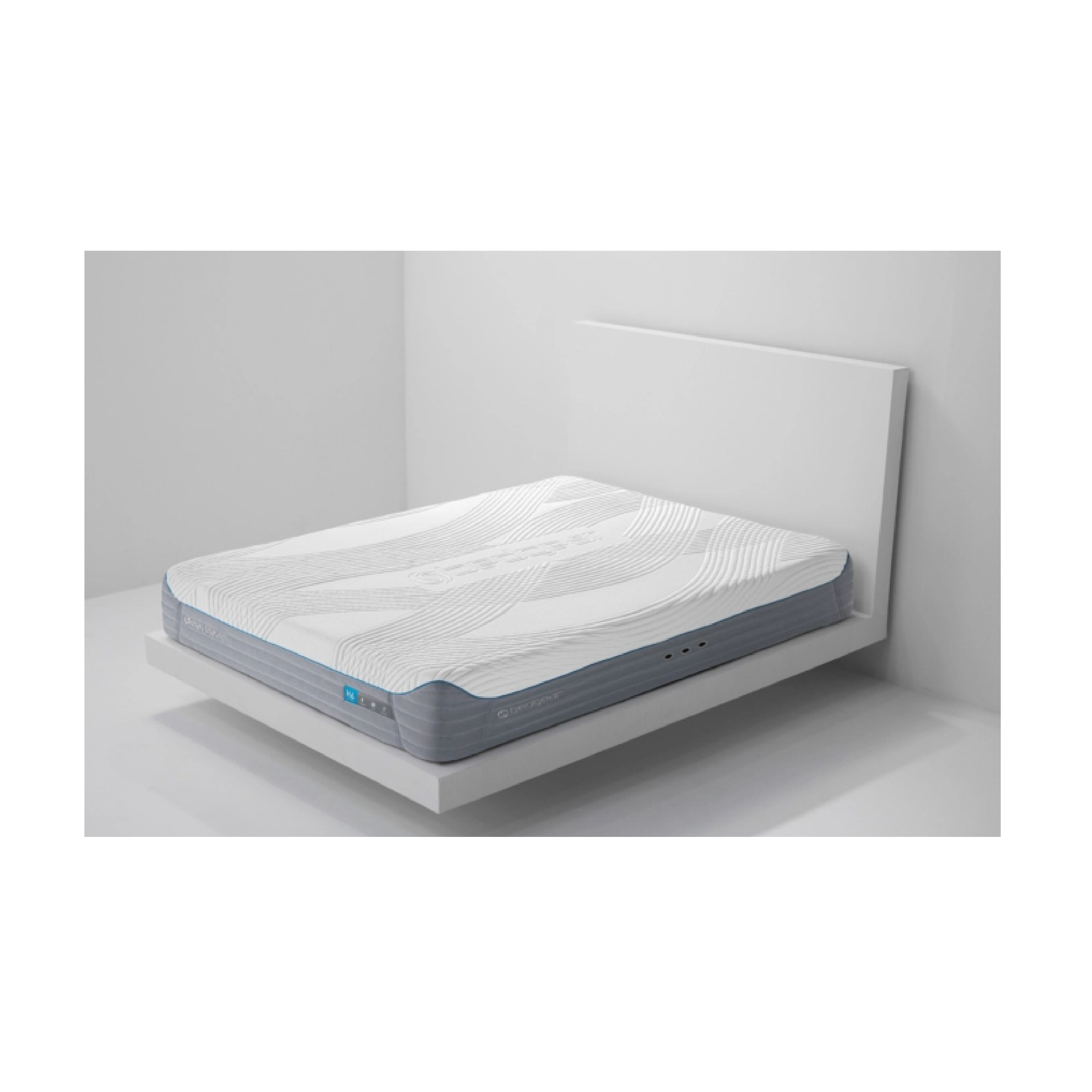 A hybrid mattress with memory foam-like material and individually wrapped coils, displayed in a white bed frame with a white wall in the background.