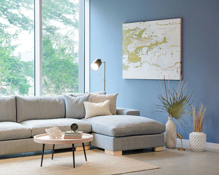 Modern living room with harlem sectional sofa, round coffee table, and decorative elements.