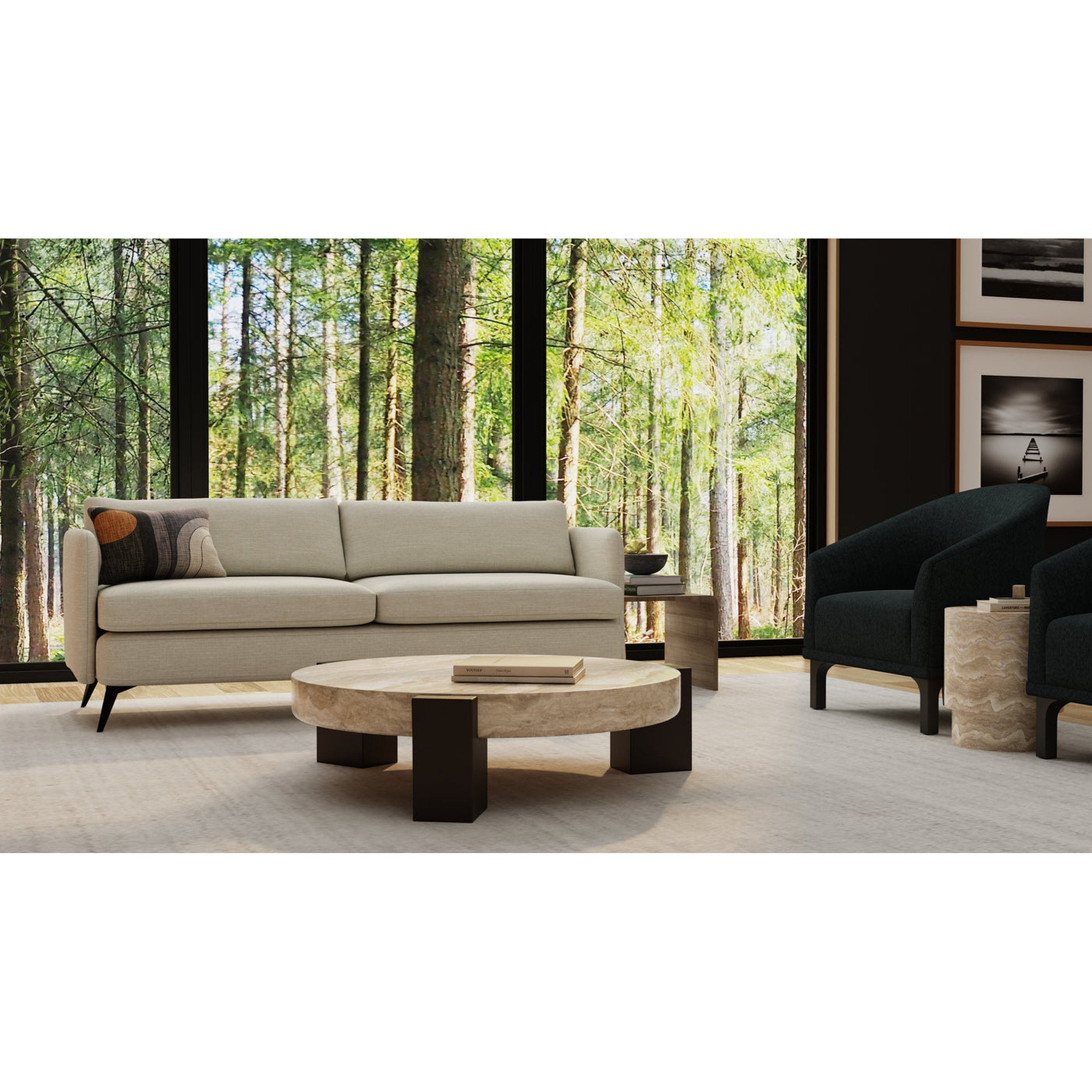 Modern living room with a beige sofa, black armchair, and round wooden coffee table in front of a large window with a forest view.