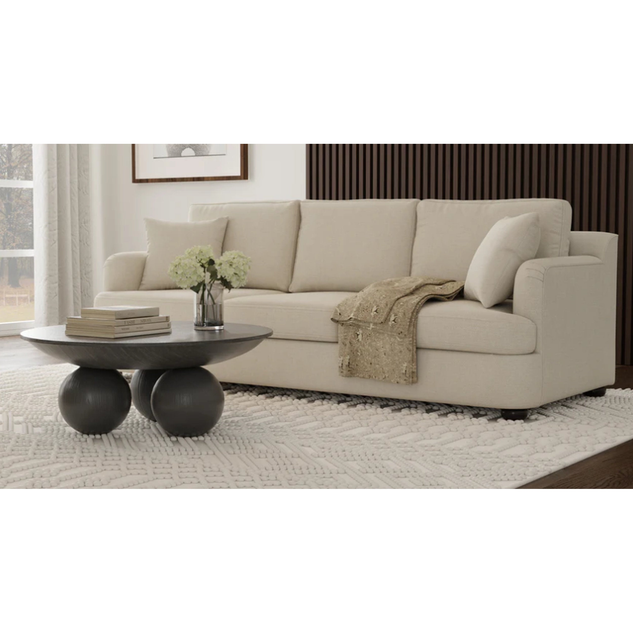 Beige sofa in a living room with a coffee table and decorative items.
