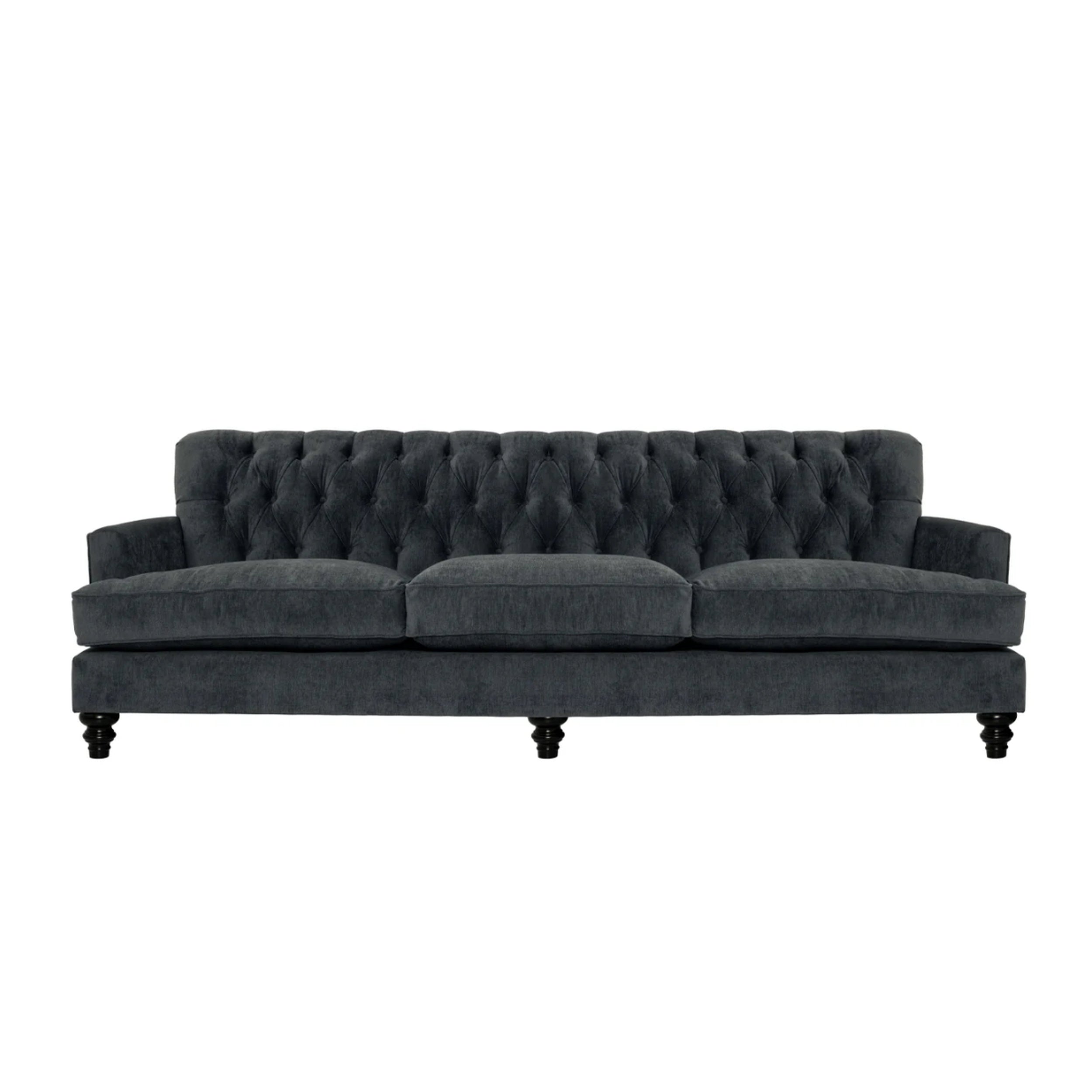 Dark gray tufted sofa on a white background