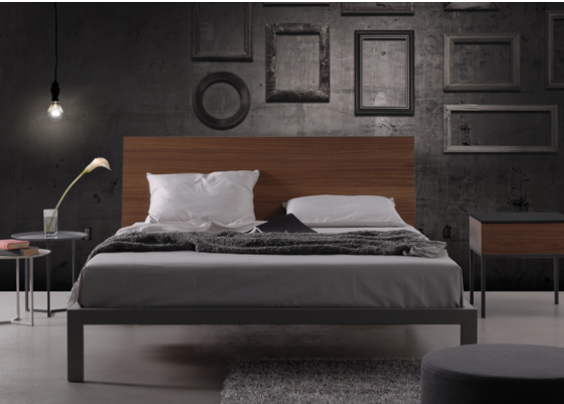 A modern platform bed with a dark gray metal frame and a wooden headboard, dressed with white and black bedding.