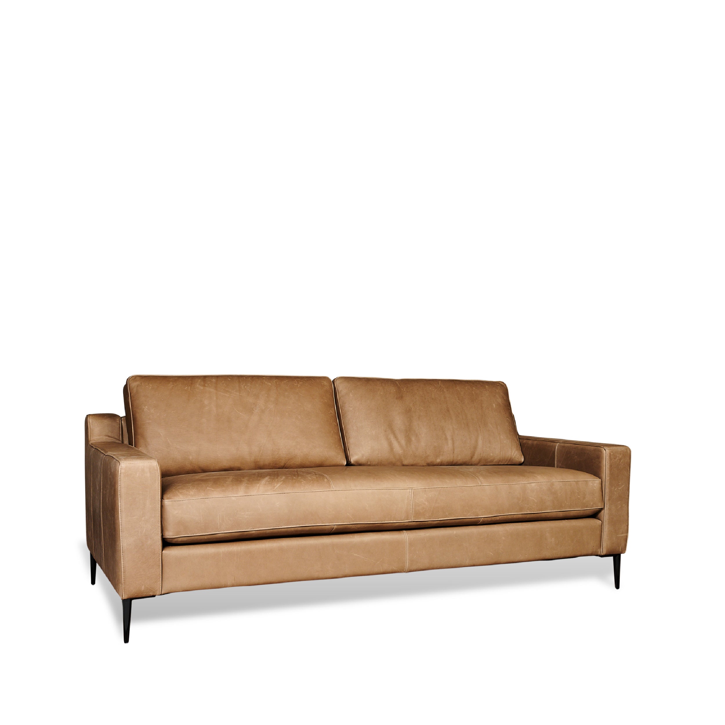 A brown leather sofa with a modern sectional design, featuring a minimalist profile with wooden legs.