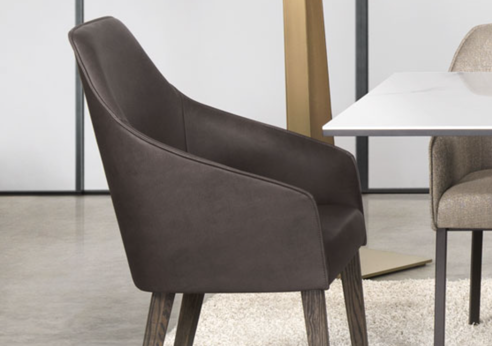 A modern dining chair with a brown upholstered seat and backrest, featuring wood oak legs