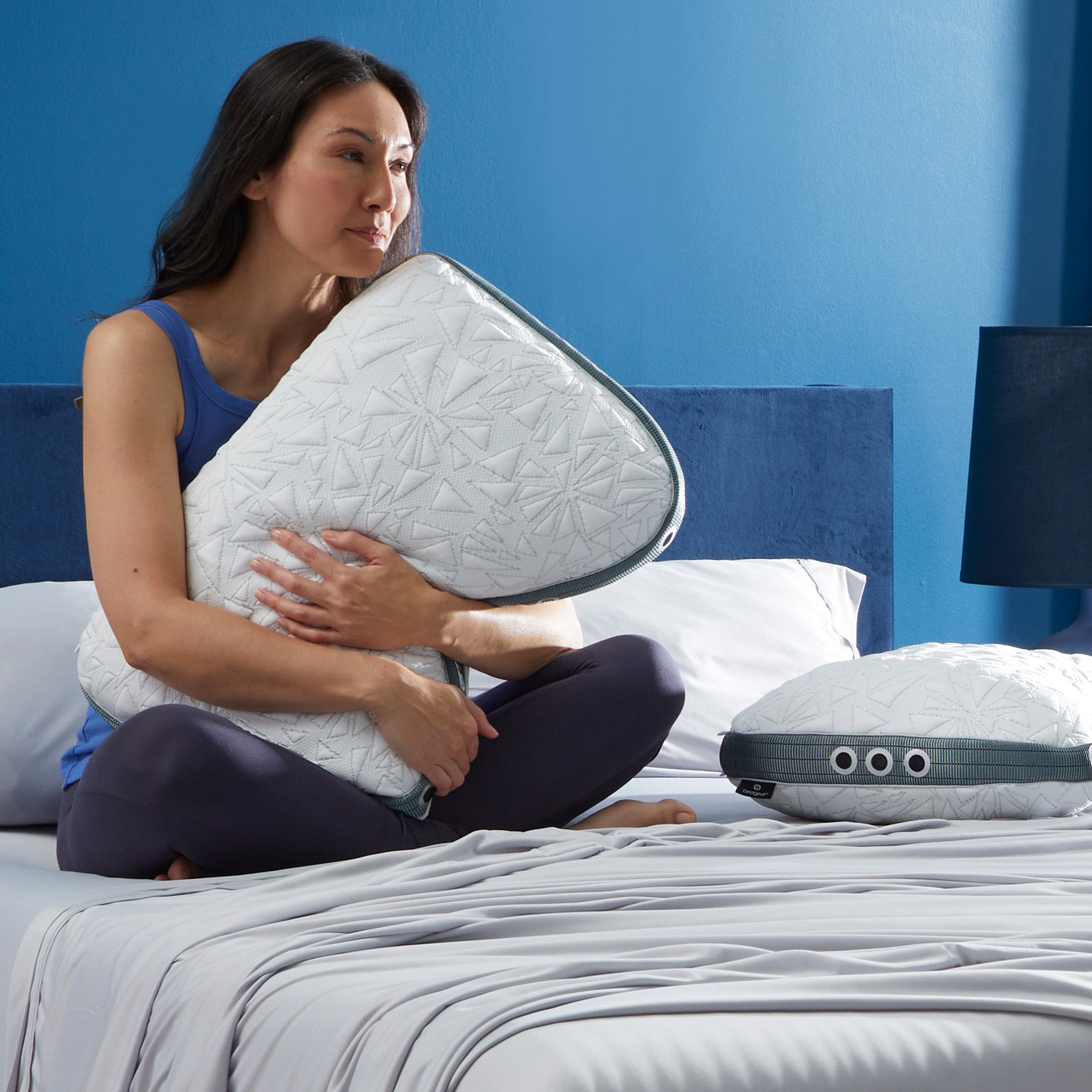 Bedgear Storm Cuddle Curve Performance® Pillow in white quilted cover with silver zipper charcoal piping, woman hugging it.
