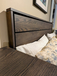 dark Wooden headboard with bedding and pillows in a bedroom setting