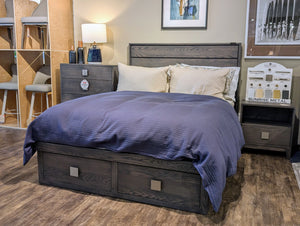 Bedroom setup with a bed, nightstands, and decor in a showroom.