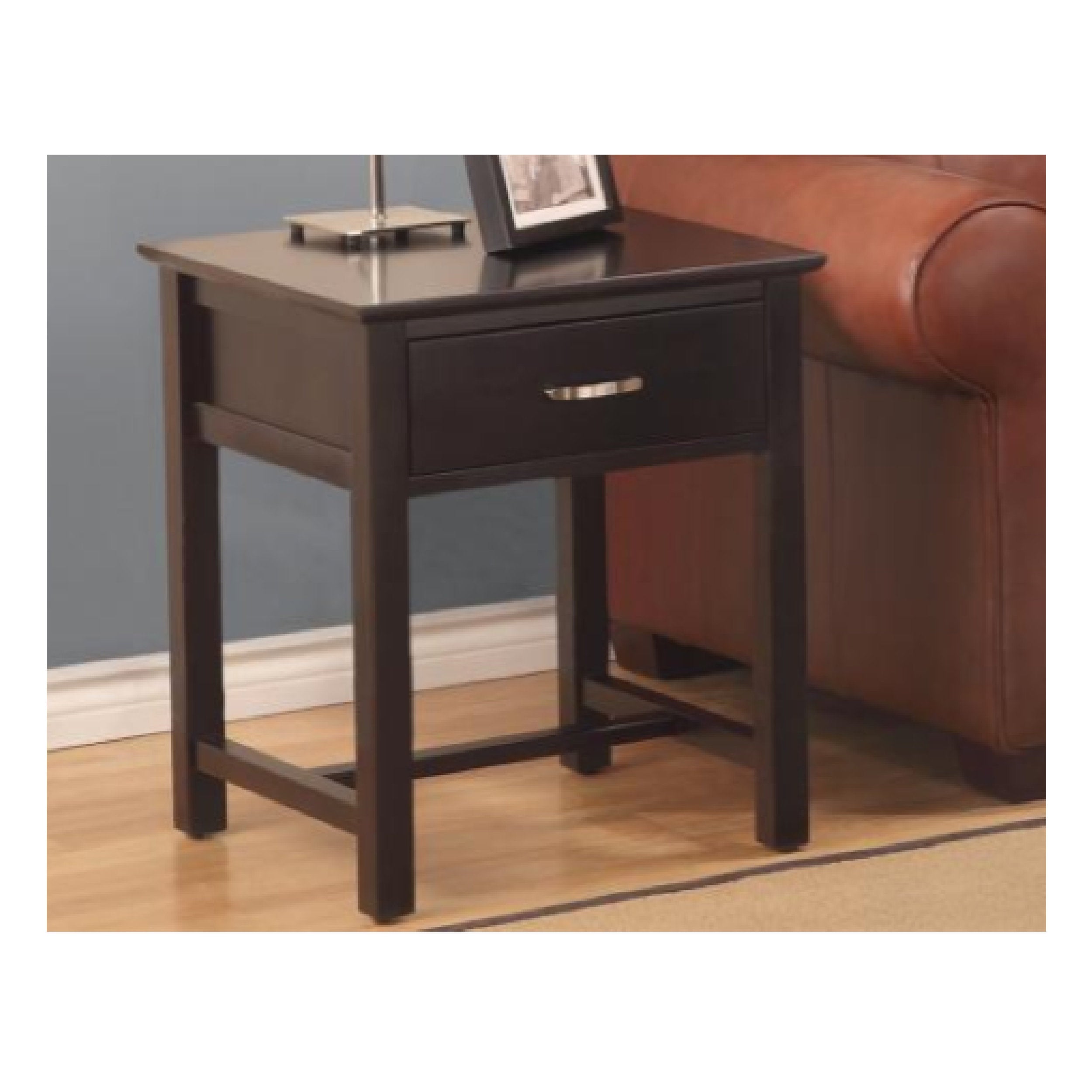 Dark wood side table with a drawer next to a brown leather couch.