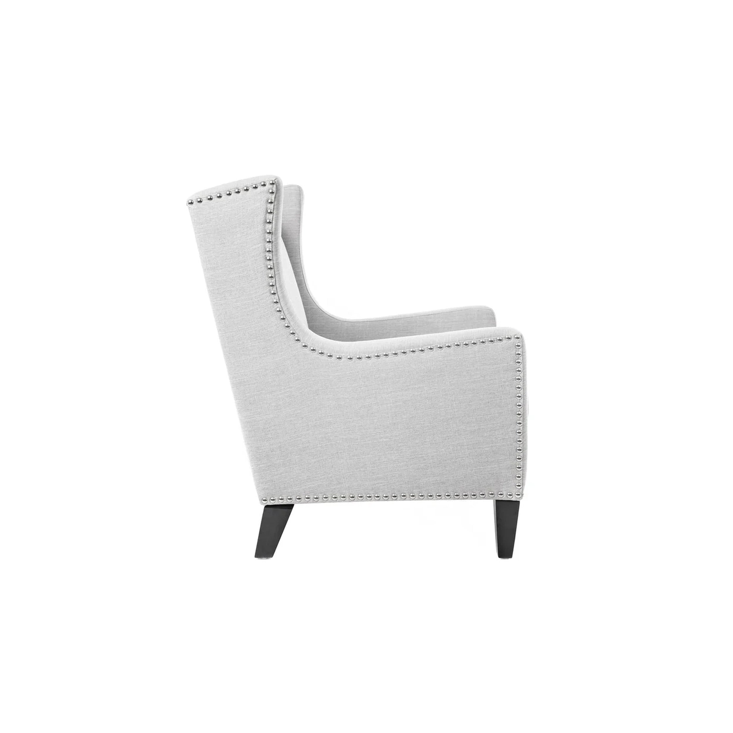 Gray armchair with nailhead trim on a white background