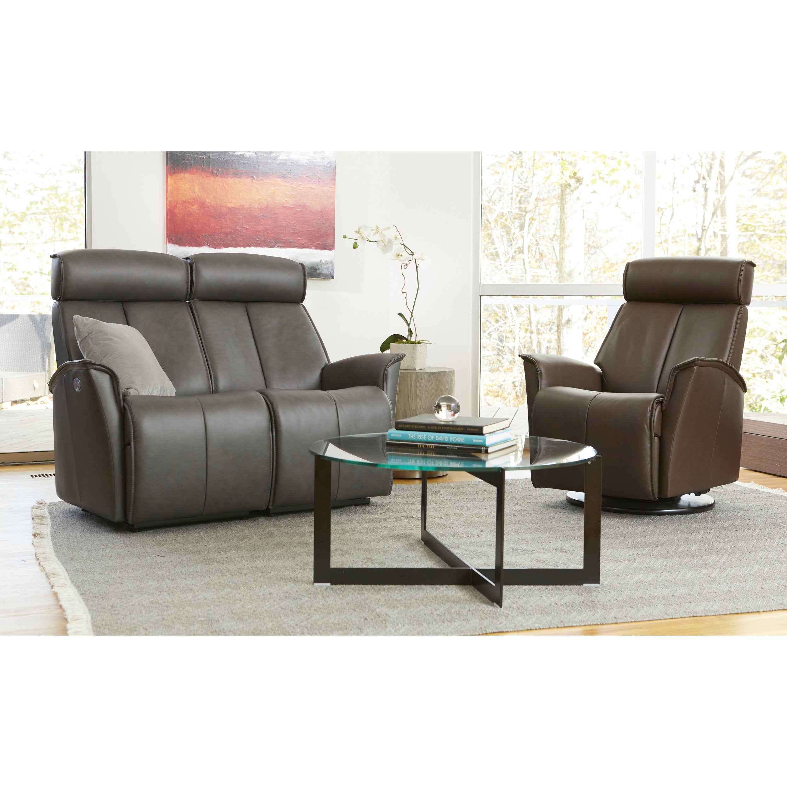 Gray reclining sofa and armchair in a living room setting with a glass coffee table.