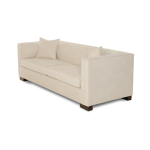 Beige sofa with two cushions on a white background