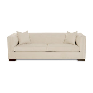 Beige sofa with two cushions on a white background