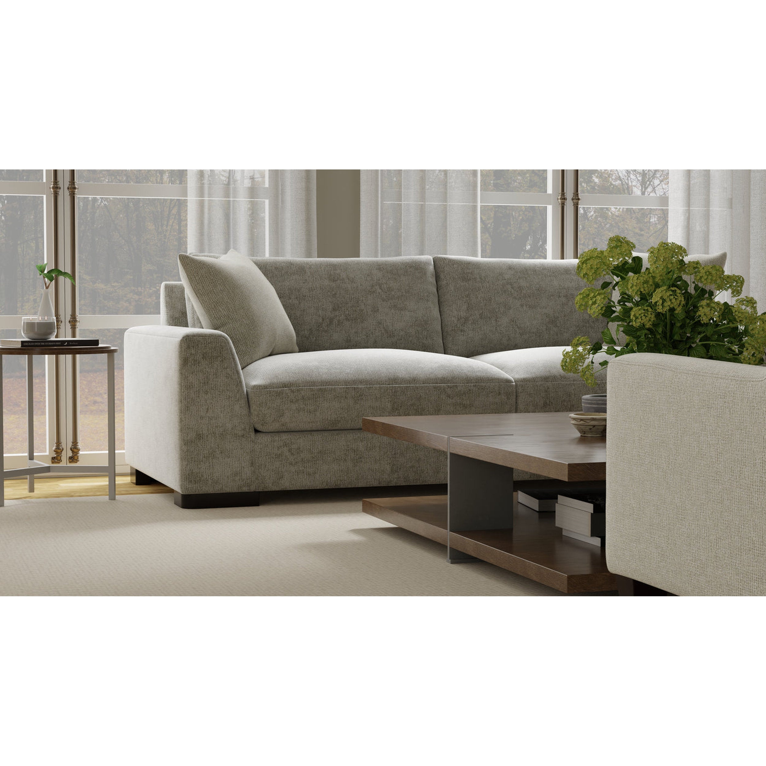 Gray sectional sofa in a living room with a wooden coffee table and plants.