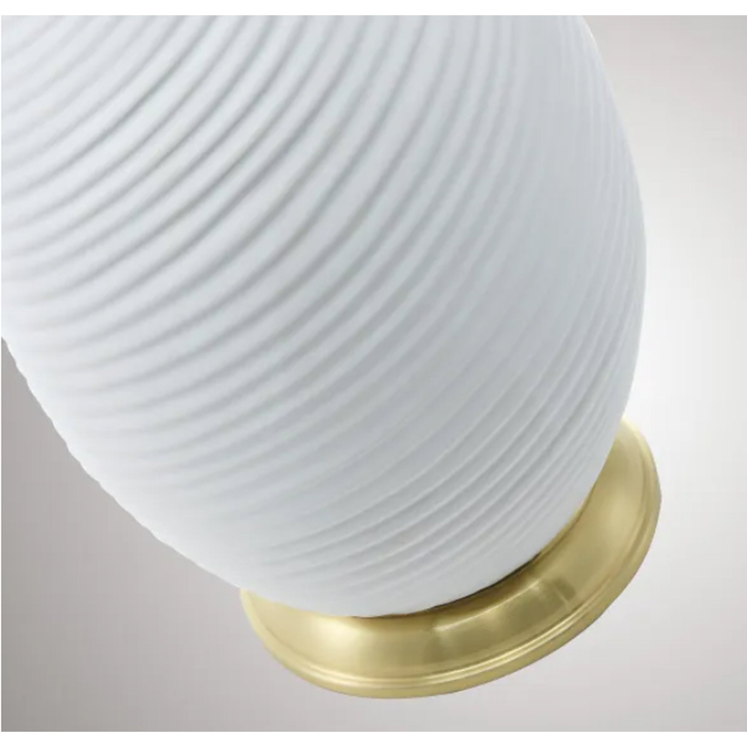 White textured lampshade with a gold base on a light gray background
