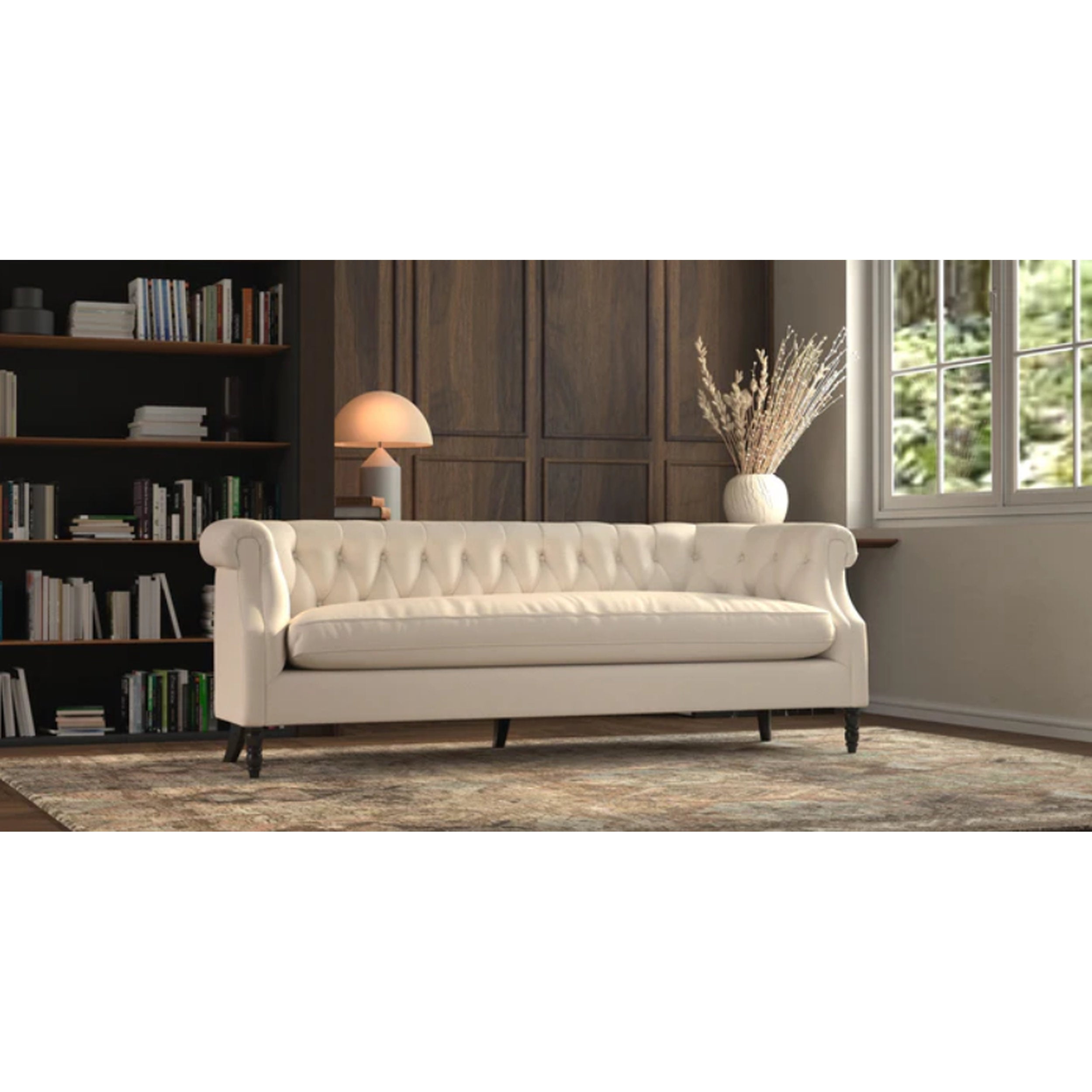 White sofa in a living room with a bookshelf and window in the background