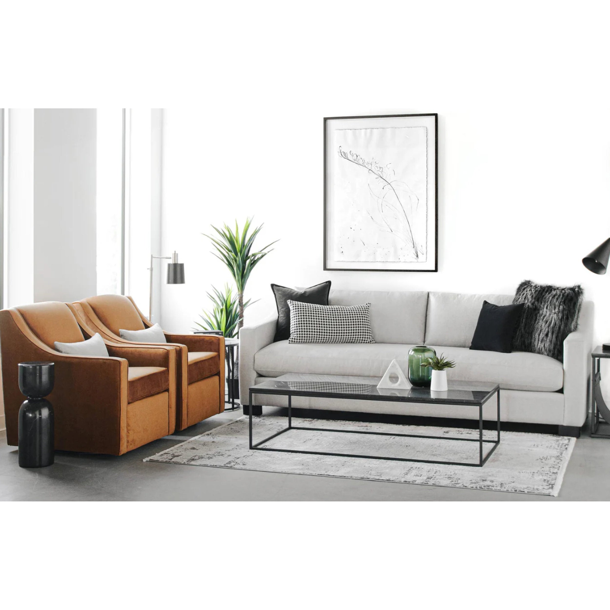 Modern living room with gray sectional sofa, brown armchairs, and a glass coffee table.
