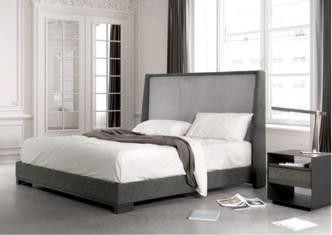 A gray upholstered bed frame with a high headboard, made of metal, shown with a white mattress and a grey throw blanket on top.